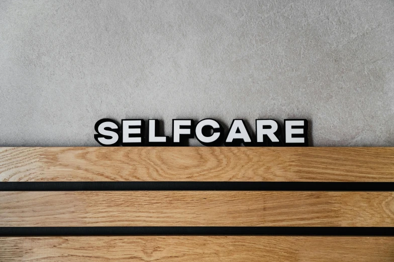 a wooden bench that has the word self care on it