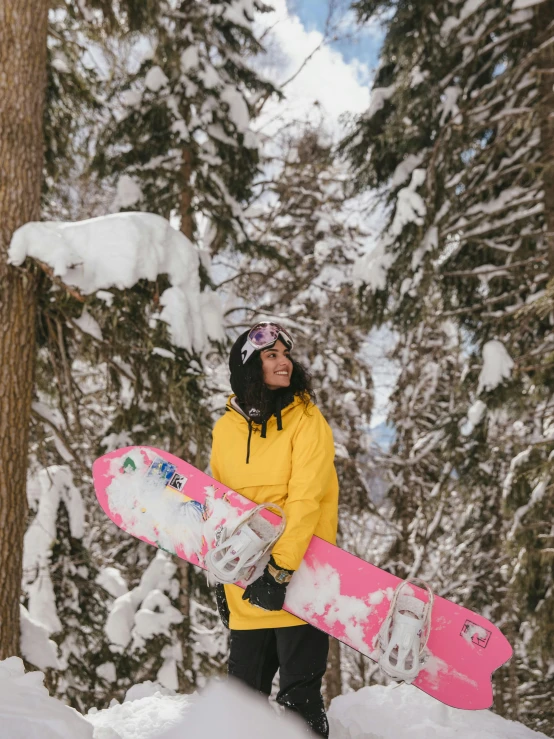 a person holds their snow board and looks up into the air