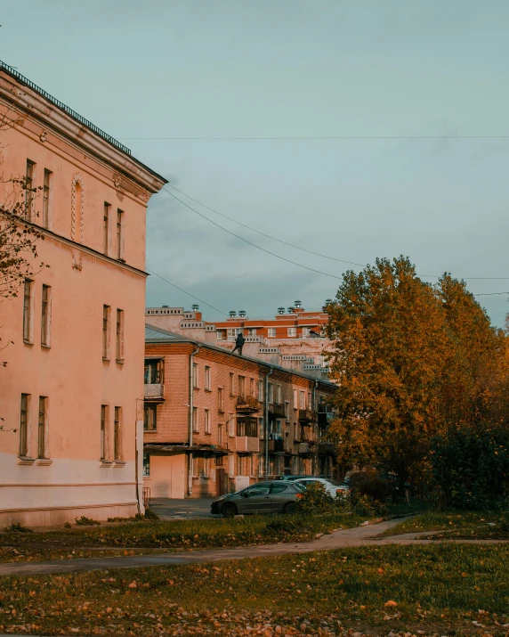 a street scene with an apartment building and parked cars