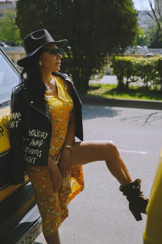 a woman leaning against the side of a car