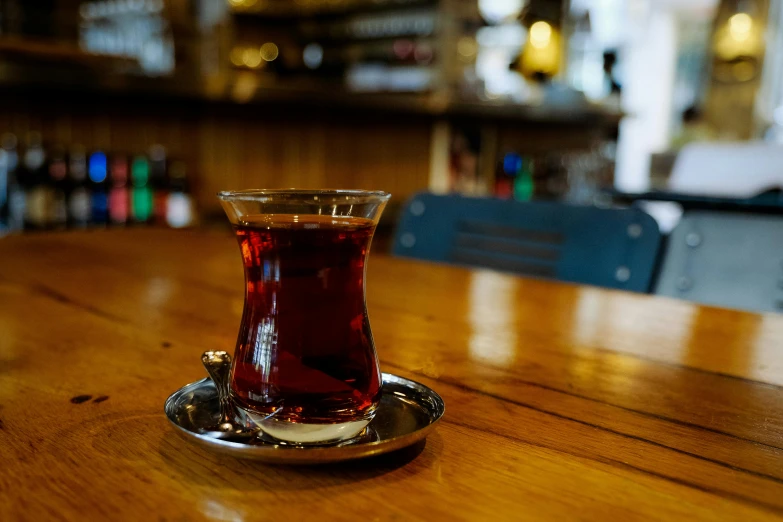 a small glass filled with liquid sitting on top of a table