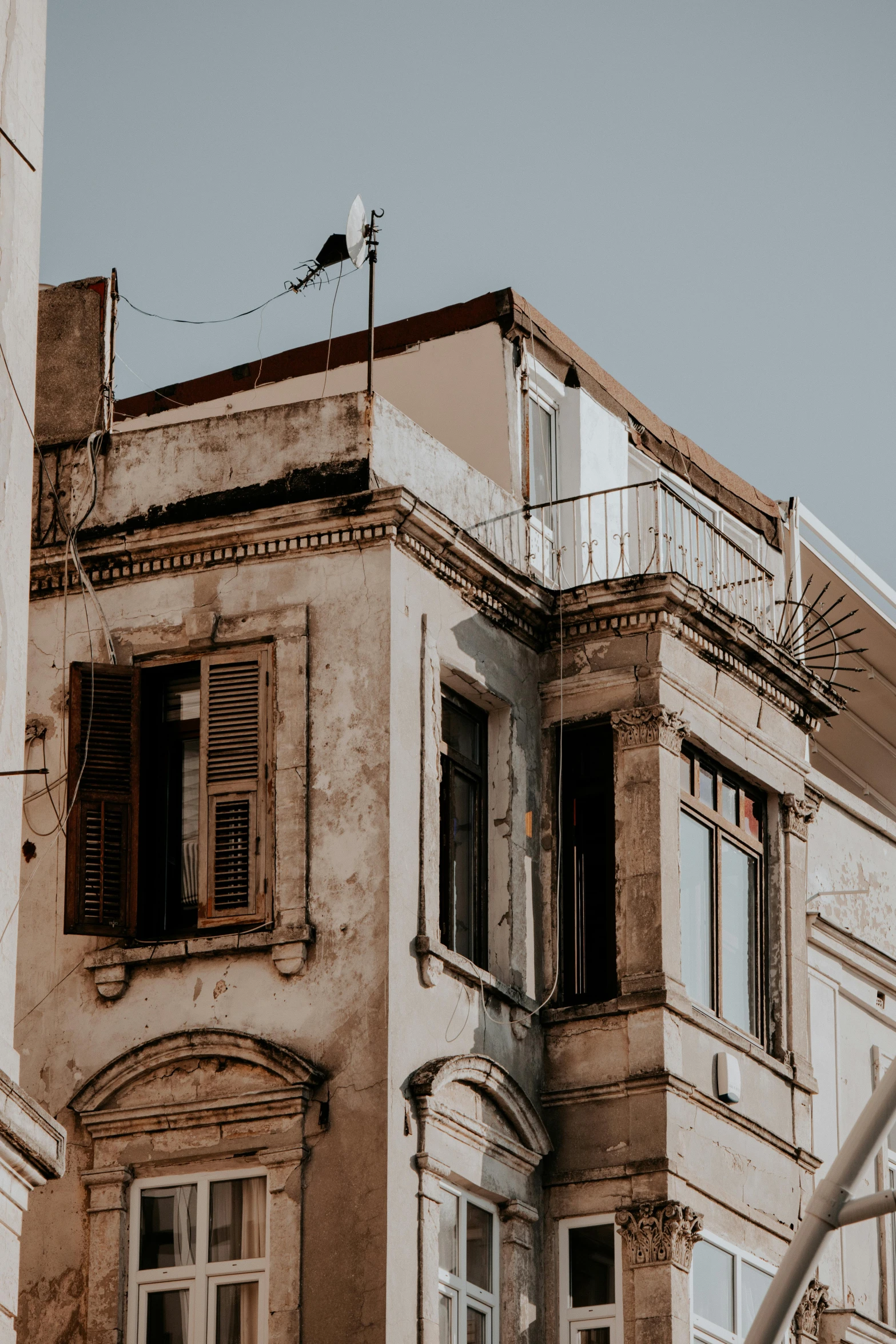 a tall brown building with three windows and a bird on top of it