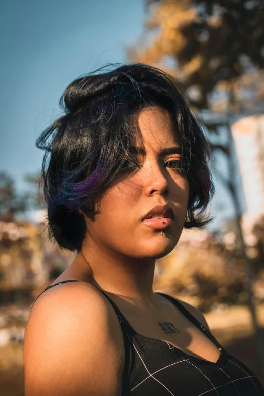 a woman in a black tank top looking off to her side