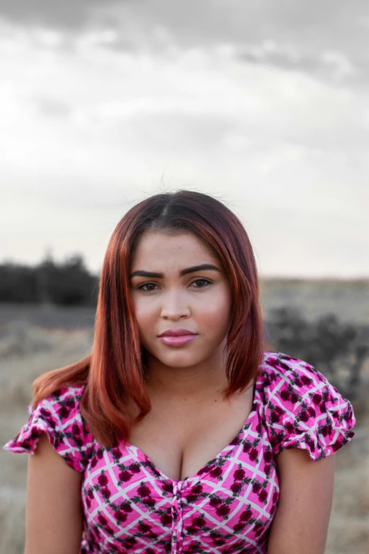 a woman standing in front of a grass field