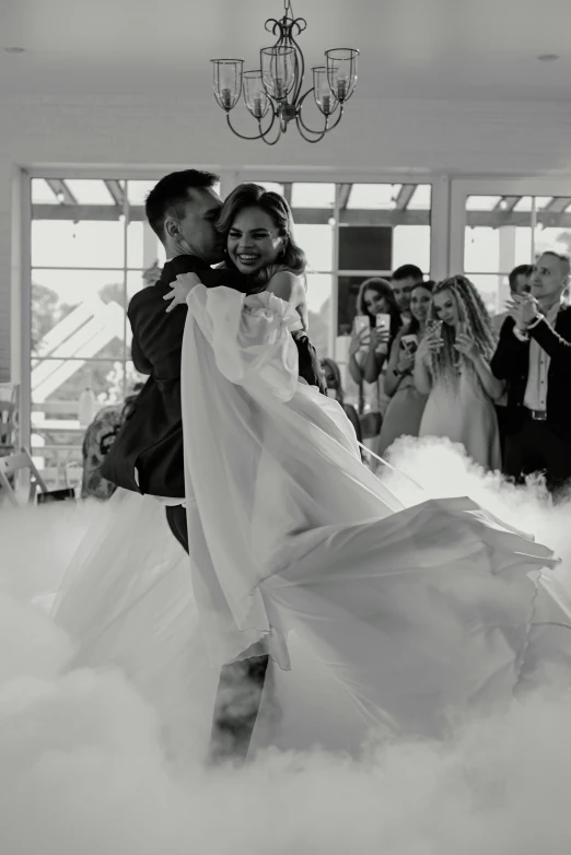 a bride is hugging her groom in the cloud