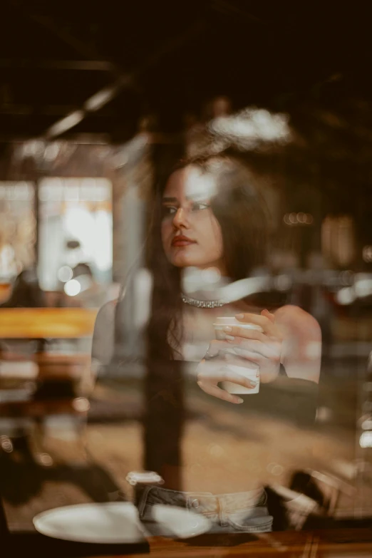 a woman sitting at a table with her arm over the top