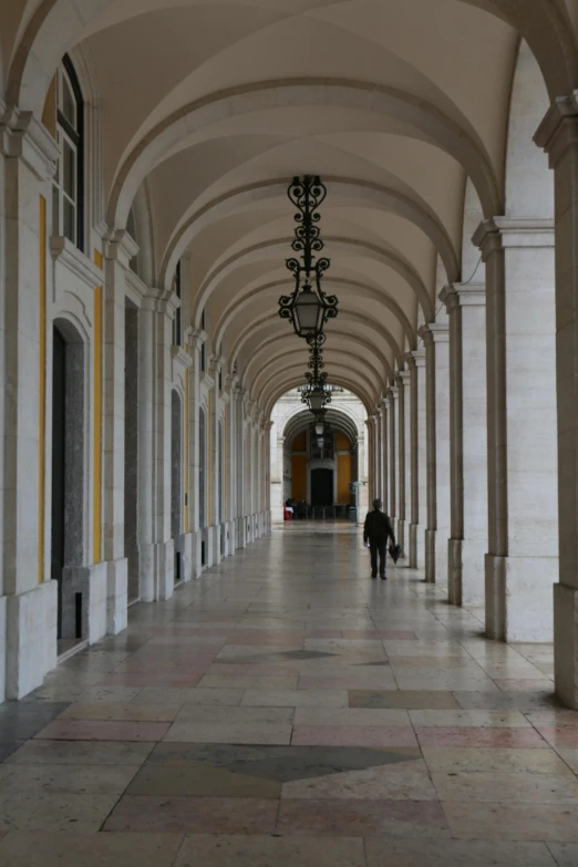 the large hallway has pillars with hanging lamps