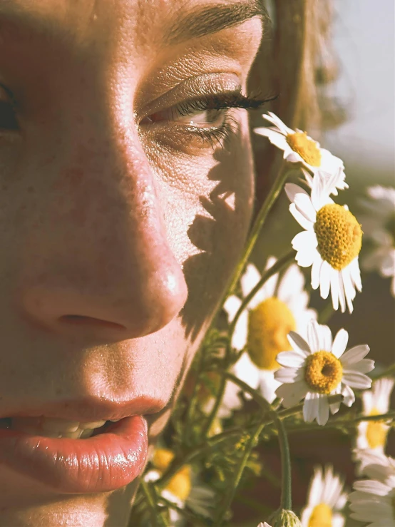 there is a woman that has her eyes closed and flowers are behind her