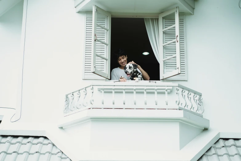 a young person with a camera looking out an open window