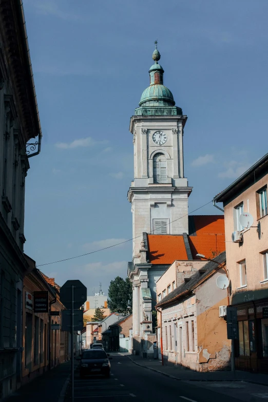 a white clock tower sitting next to a tall building