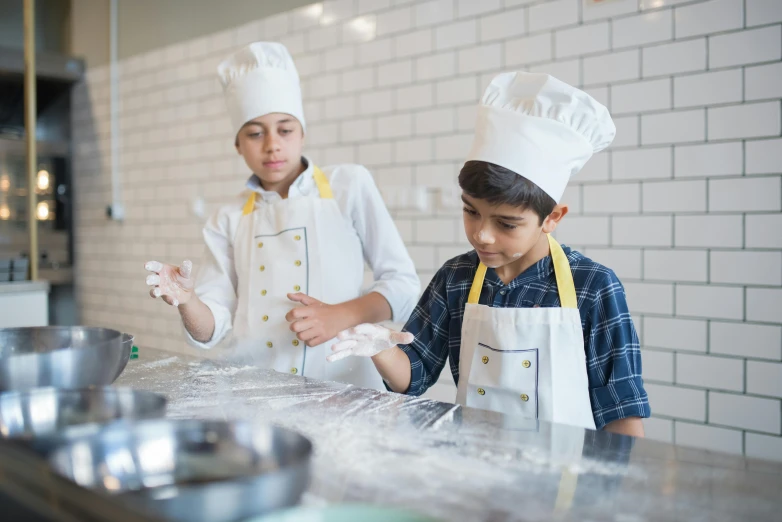 two s are in a kitchen preparing food