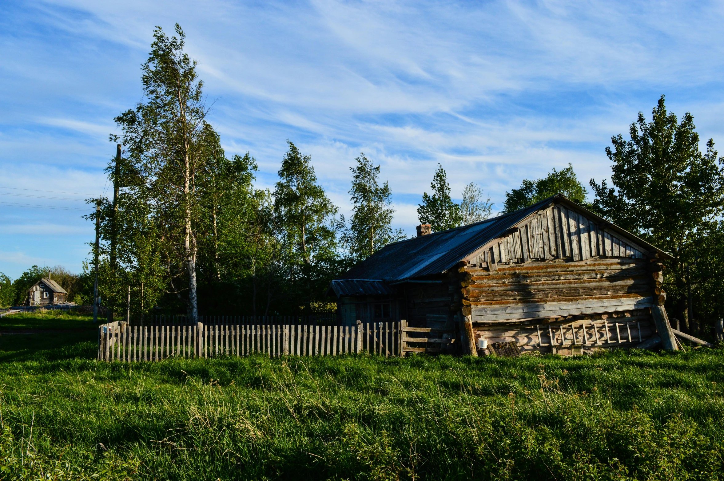 the shed is in the grass by the fence