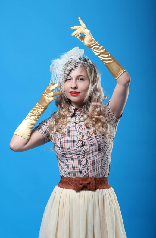 a woman dressed up in a dress with gloves and a hat