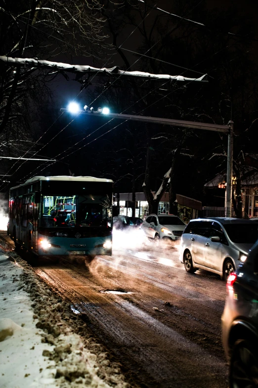 a bus and cars driving down a snowy street