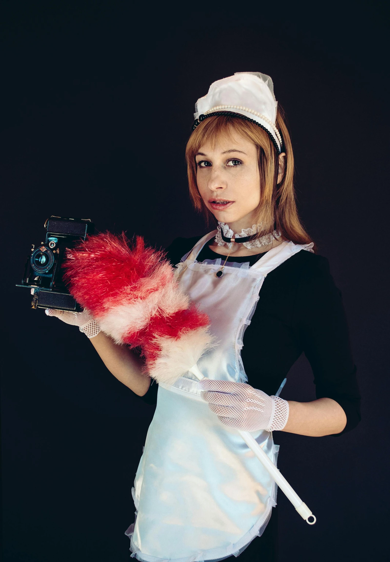 a woman holding a red ballpoint glove and wearing an apron