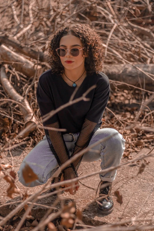 a young woman with red makeup sitting on top of a dirt ground