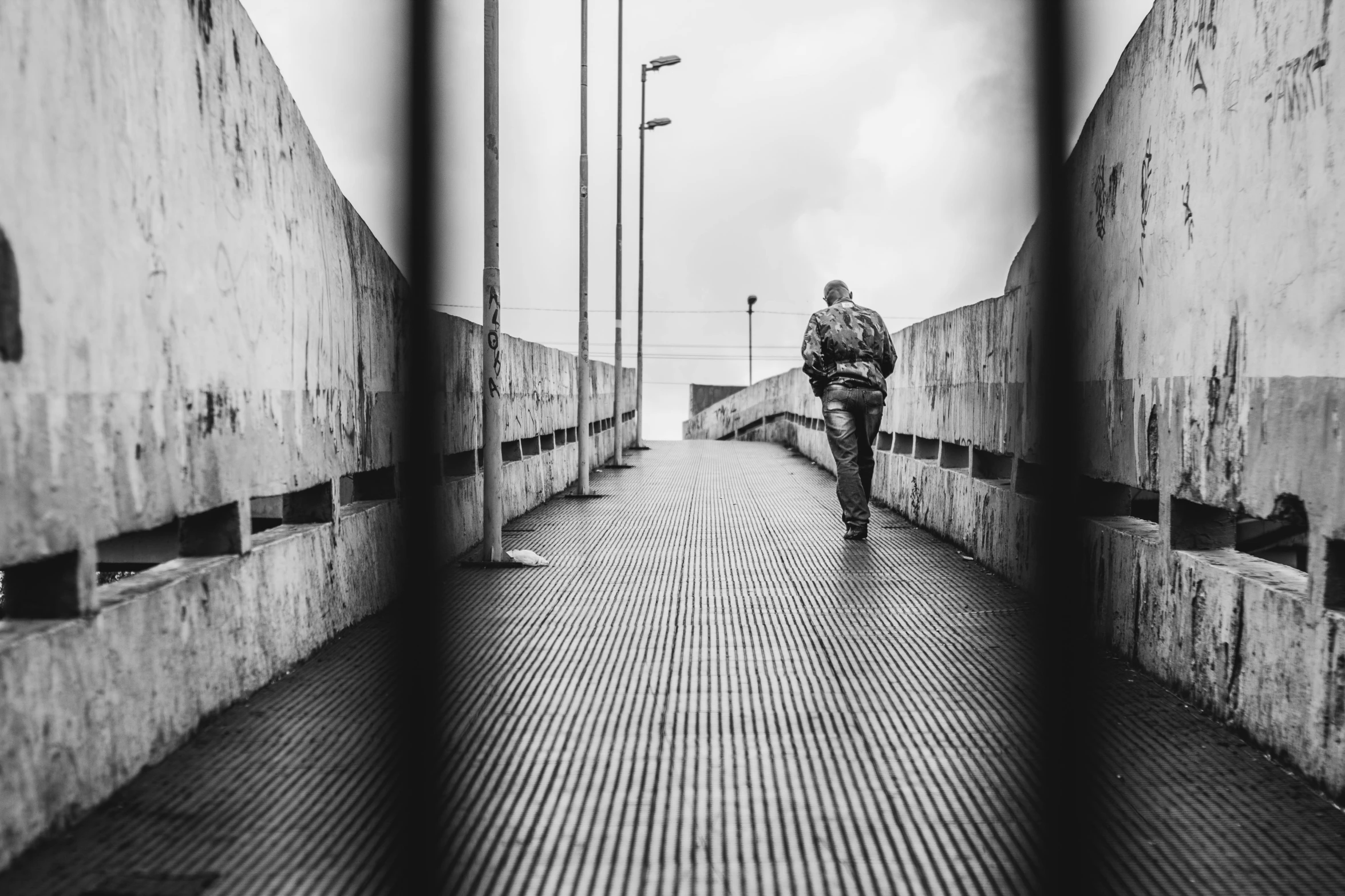 a person walking on an elevated walkway in an alley