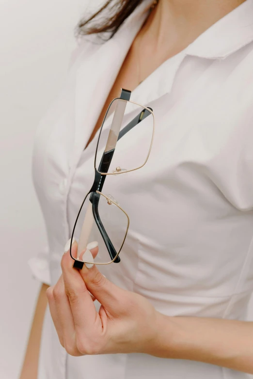 a person wearing glasses while holding their left hand