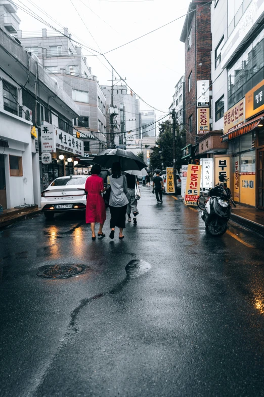 people walking down the street while holding umbrellas