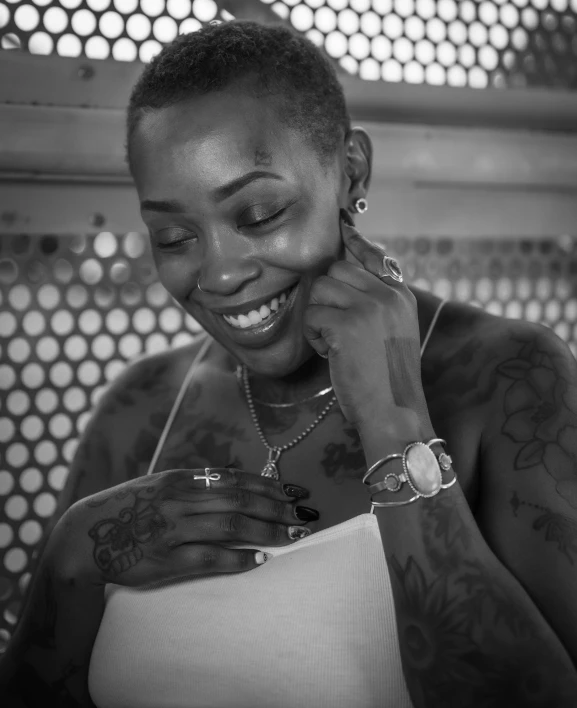 a woman smiles with her ear covered by tattoos