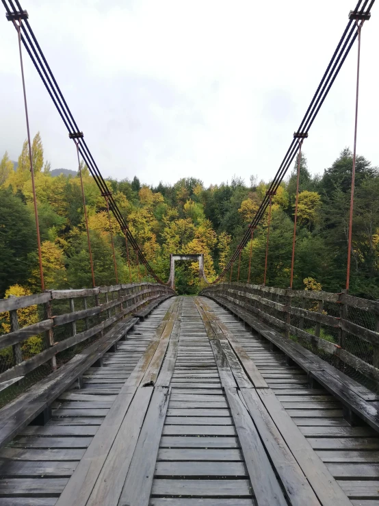 a old bridge going over a river with wooden rails