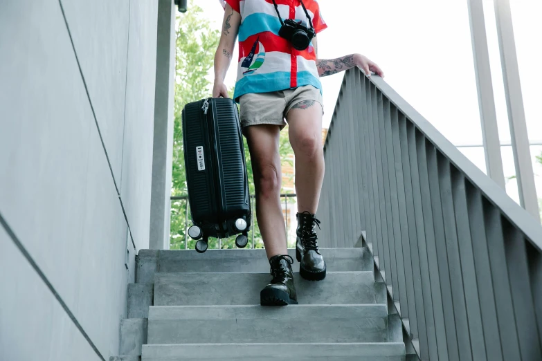 a person carrying luggage down some steps with a backpack