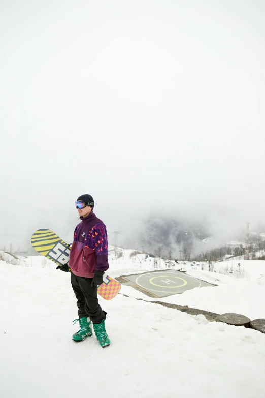 the person is standing in the snow holding his snow board