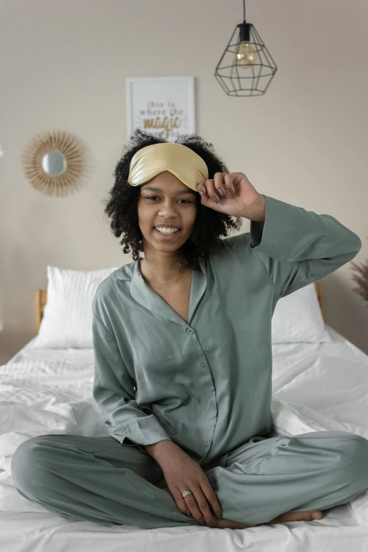 a woman sitting on the ground with a towel covering her eyes