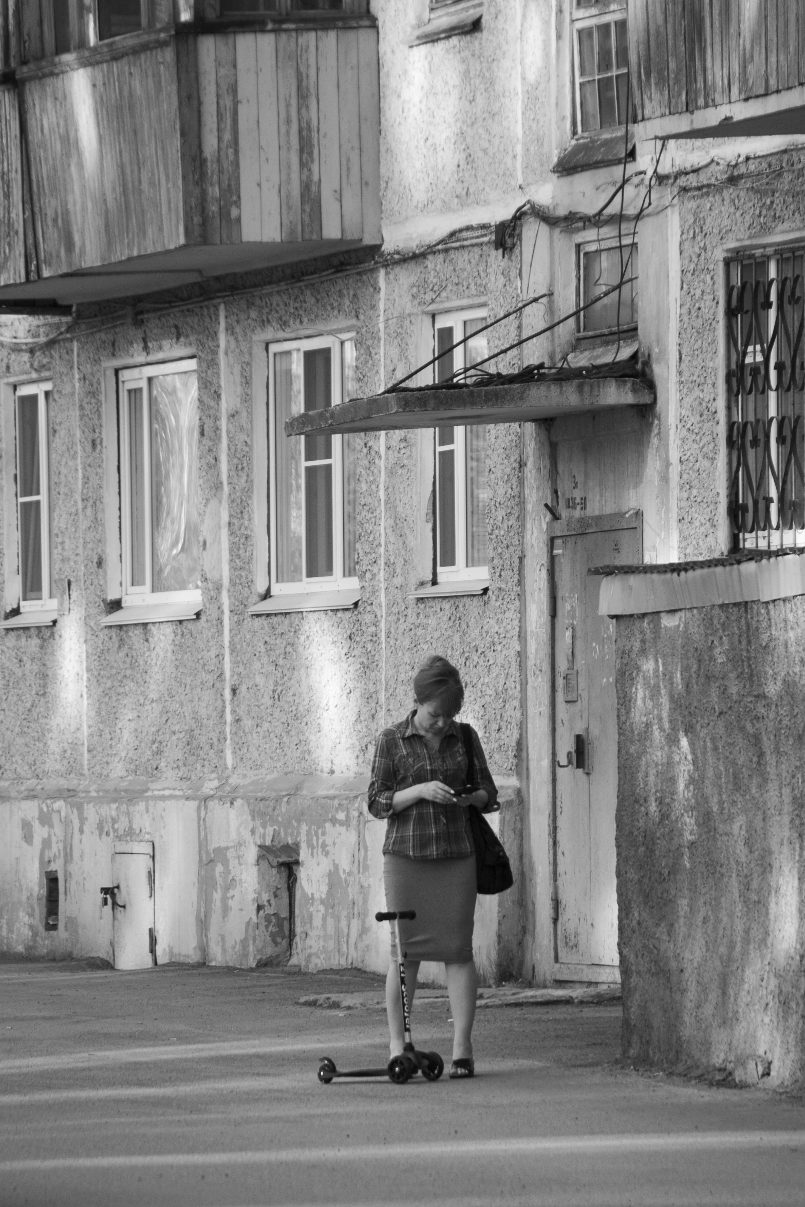 an older woman stands on her skateboard in front of a very old building