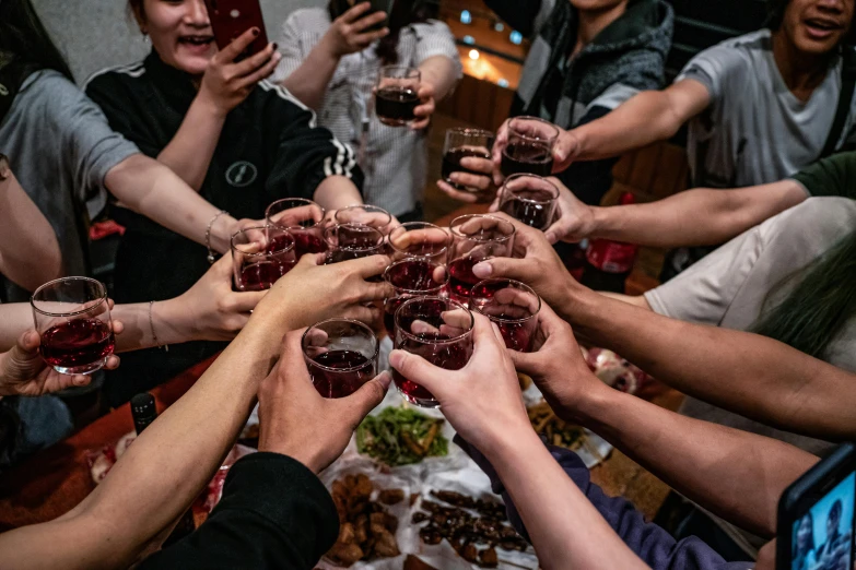 a group of people are standing together holding drinks in their hands