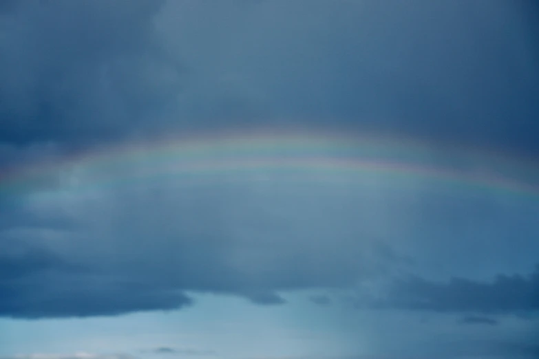 a rainbow in the sky on a cloudy day