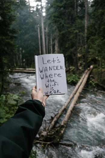 a person holding a piece of paper saying let's wander where the wild is weak