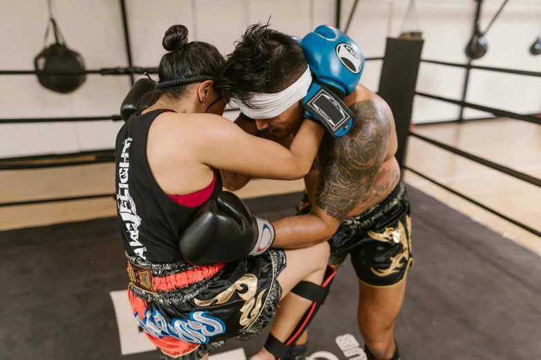 two people in boxing gear sitting on a ring