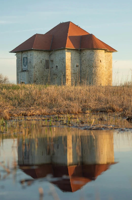 old water house sitting in the middle of a marsh