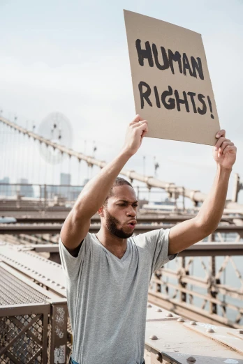 man holding up sign reading human rights