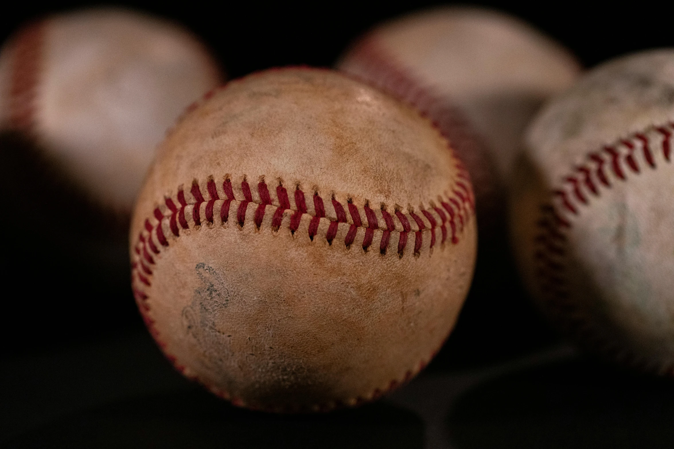 three baseballs and balls are sitting on the table