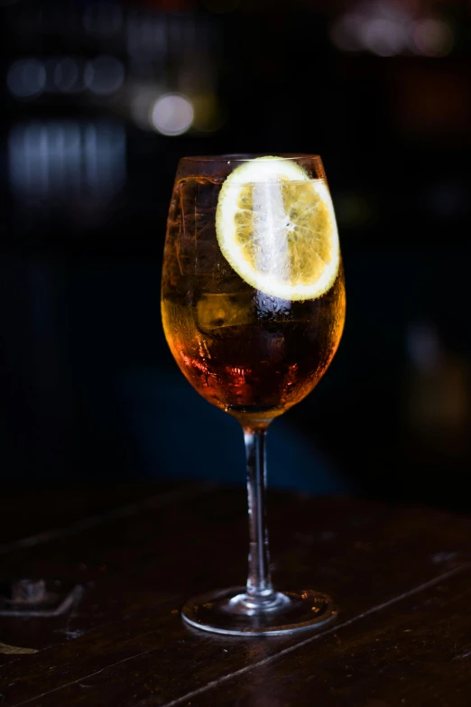 a clear glass filled with a soda sitting on top of a wooden table