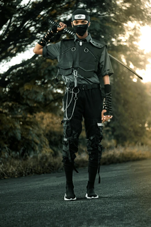 a man in all black standing in the middle of the road