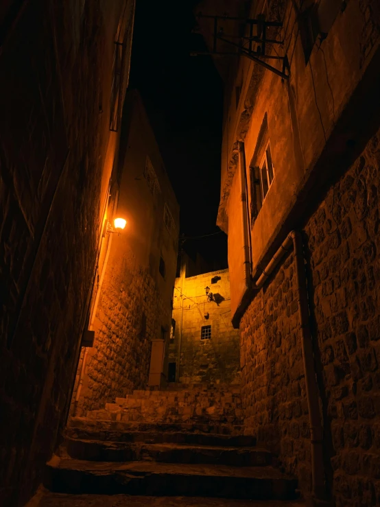 a dimly lit stairway that leads up into an alley