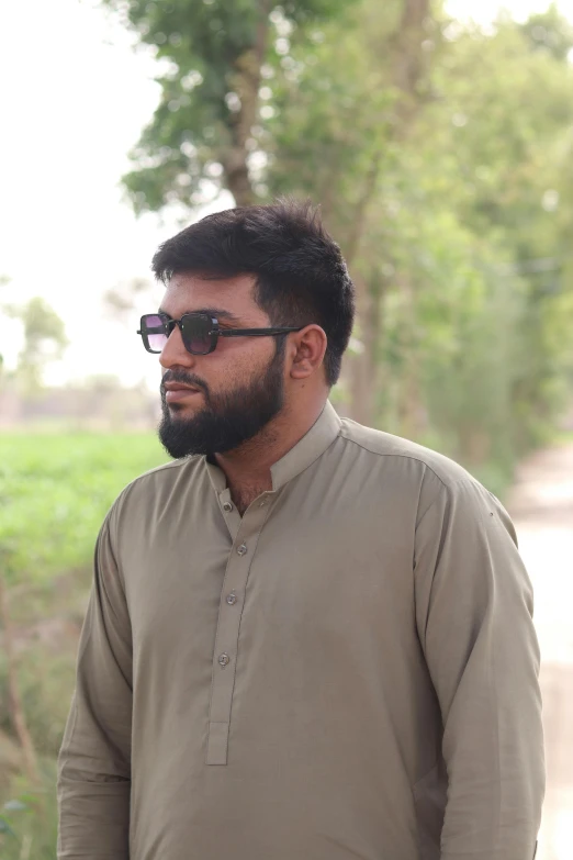 a man with a beard is wearing glasses and looks towards the left