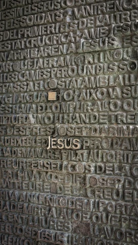 a wall with words written on it and a cross
