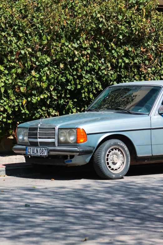 the old blue car is parked on the side of the street