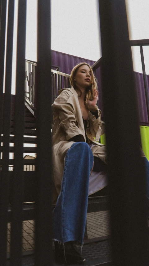 a woman sitting on top of a bench talking on a cell phone