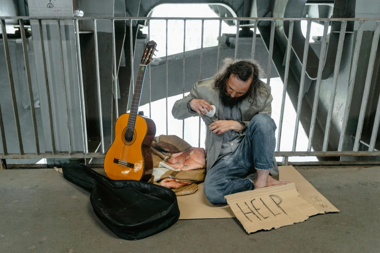 a man sitting on a luggage bag next to guitar cases