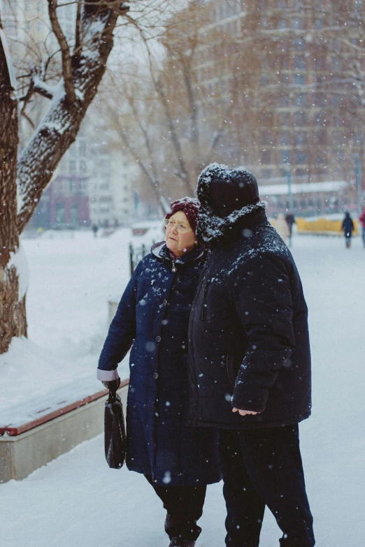 two men standing in the snow, one of them looking away