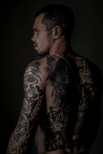 a man with tattoos on his body posing for the camera
