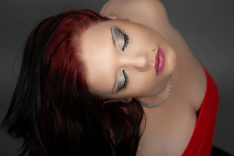 a beautiful young woman with red hair wearing black eyeliners