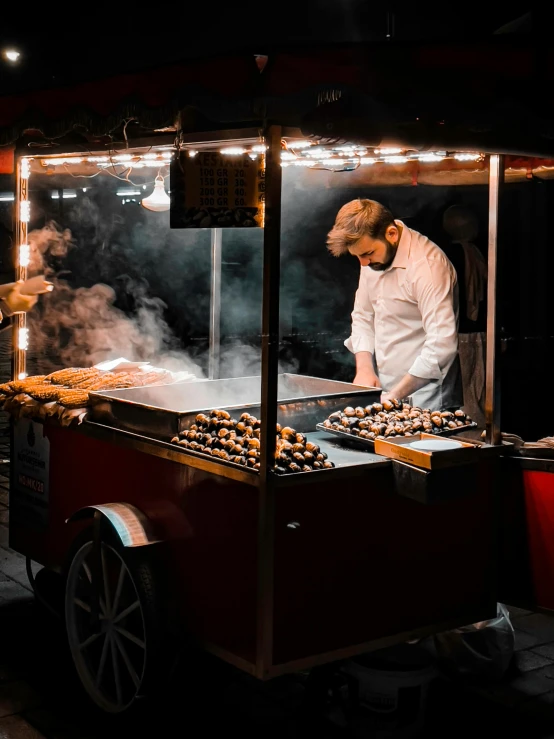 a man in a white coat cooking some food