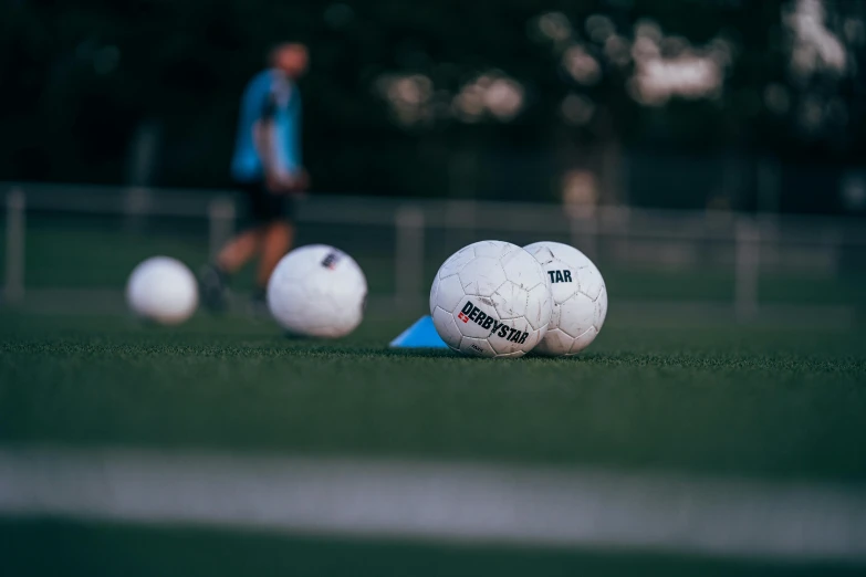 several white balls sitting on the ground near one another