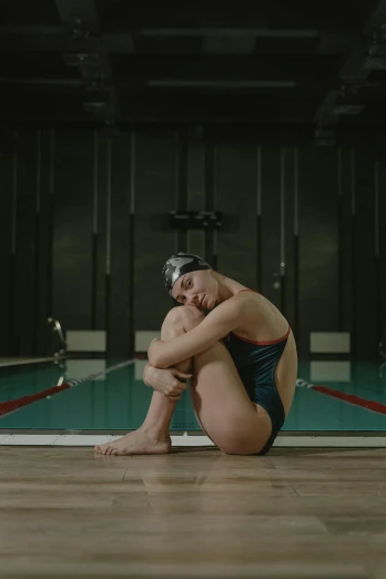 a swimmer sits on the floor in a swimming pool